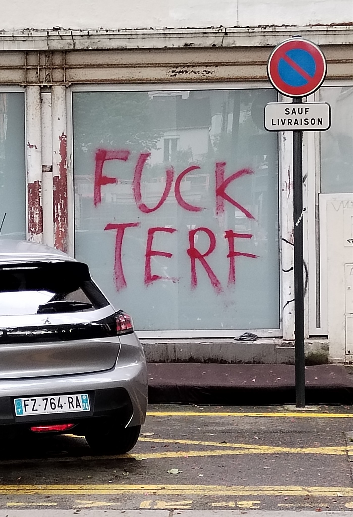 Store window with graffiti that says fuck terf